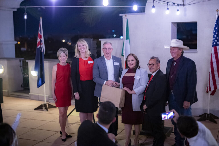 Six people standing up at an event outside being recognized.