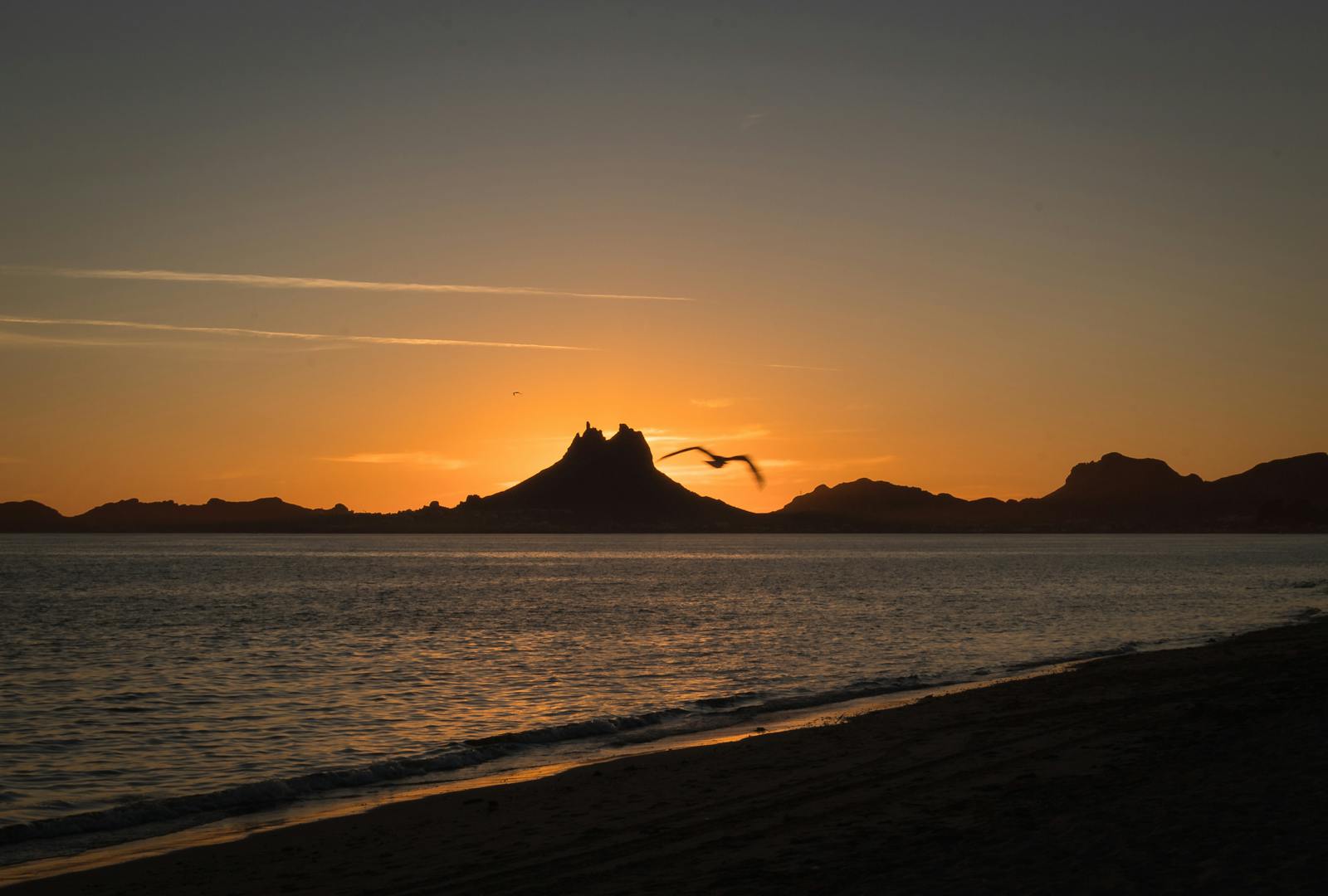 A tranquil sunset scene at San Carlos Nuevo Guaymas with Tetakawi Mountain silhouetted against the horizon.