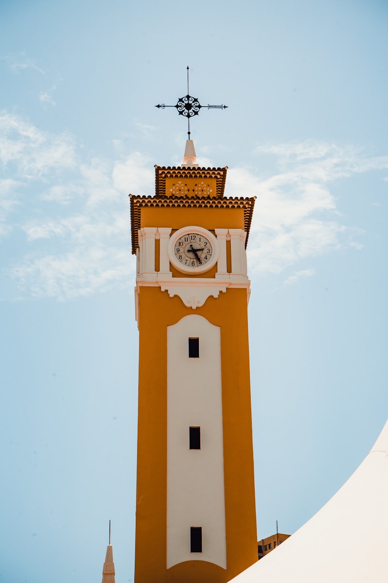 a clock tower with a weather vane